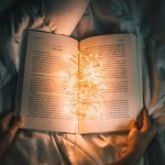 Storytelling Heart - person holding string lights on opened book
