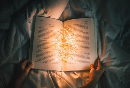 Storytelling Heart - person holding string lights on opened book