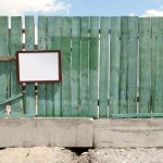Barriers Wall - a wooden fence with a mirror hanging on it
