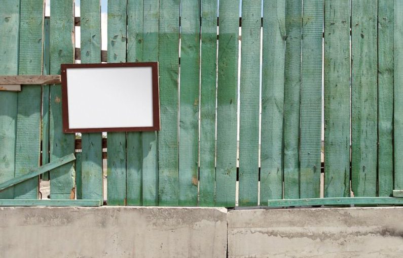 Barriers Wall - a wooden fence with a mirror hanging on it