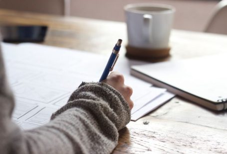 Mentorship Guidance - person writing on brown wooden table near white ceramic mug