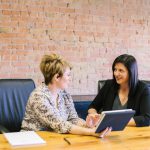 Female Leader - two women sitting on leather chairs in front of table