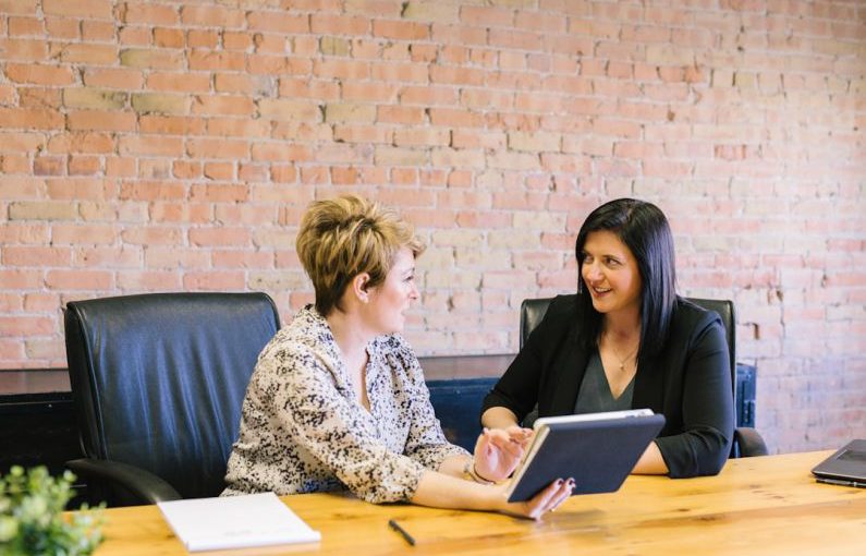 Female Leader - two women sitting on leather chairs in front of table