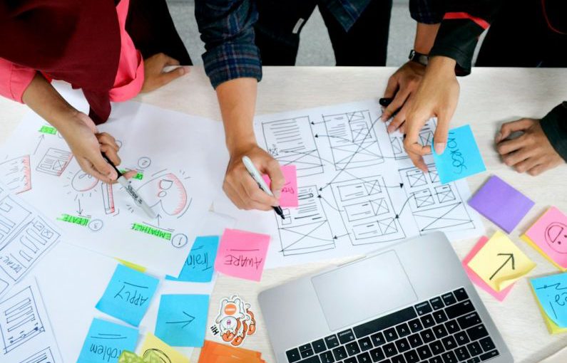 Design Thinking - person writing on white paper