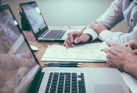 Growth Strategy - person holding pencil near laptop computer