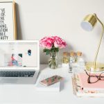 Branding Strategy - MacBook Air beside gold-colored study lamp and spiral books