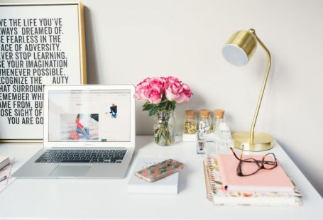 Branding Strategy - MacBook Air beside gold-colored study lamp and spiral books