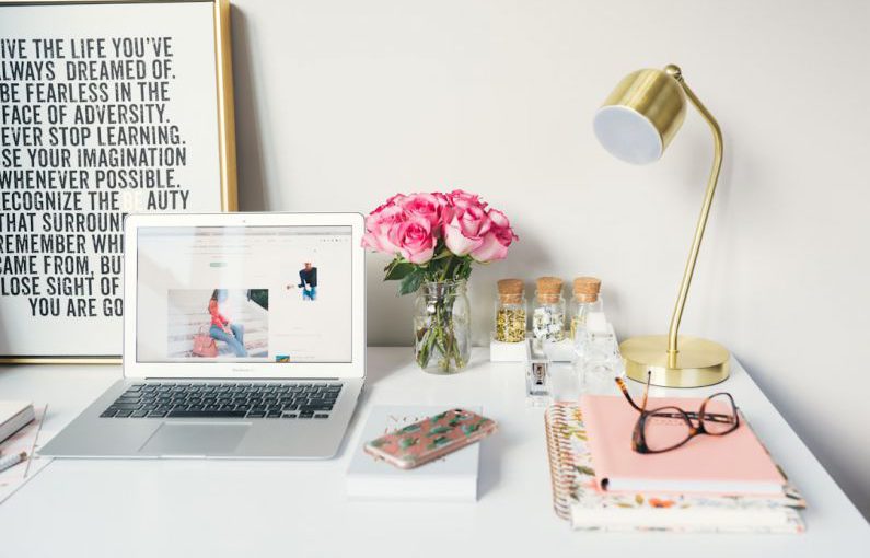 Branding Strategy - MacBook Air beside gold-colored study lamp and spiral books