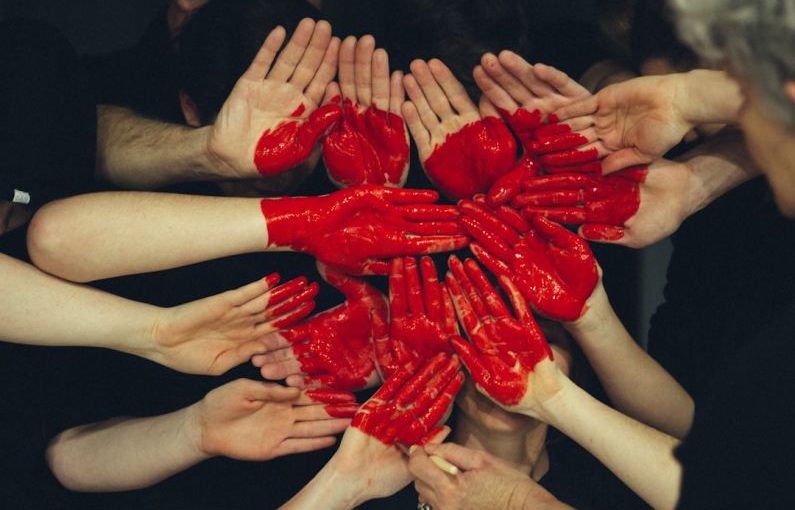 Volunteers Heart - hands formed together with red heart paint