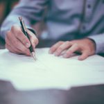 Investing Guide - man writing on paper
