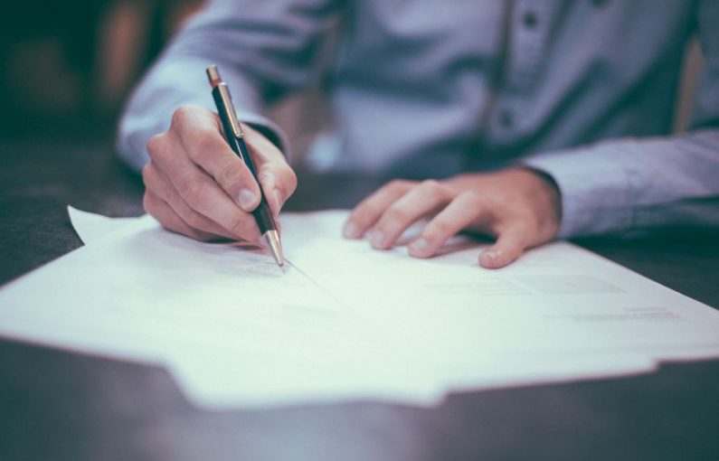 Investing Guide - man writing on paper
