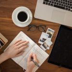 Education Impact - person holding ballpoint pen writing on notebook