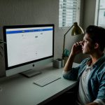 Social Bonds - man in blue denim jacket facing turned on monitor