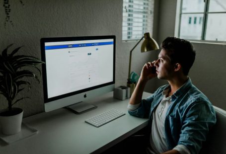 Social Bonds - man in blue denim jacket facing turned on monitor