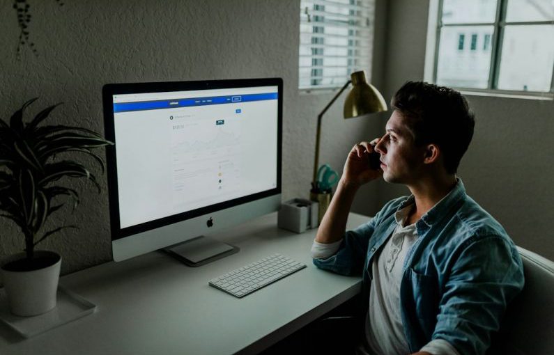 Social Bonds - man in blue denim jacket facing turned on monitor