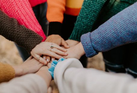 Community Engagement - person in red sweater holding babys hand