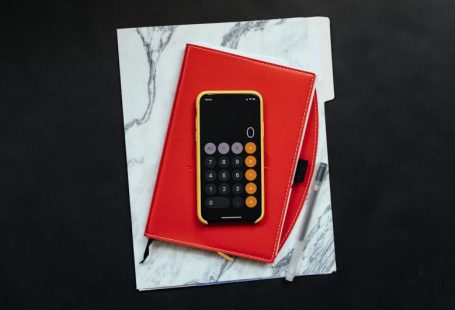 Funding Resources - black Android smartphone on red flip case