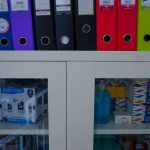 Financial Instruments - a glass door cabinet with a bunch of folders on top of it