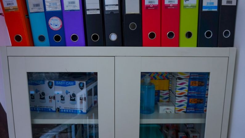Financial Instruments - a glass door cabinet with a bunch of folders on top of it