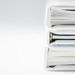 Ethics Book - A stack of thick folders on a white surface