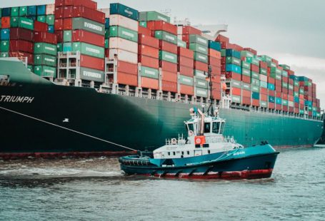 Supply Chain - a tug boat pulling a large container ship