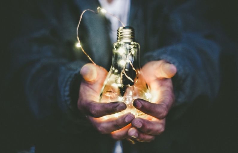 Innovation Eco - man holding incandescent bulb
