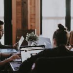 Collaboration Team - selective focus photography of people sits in front of table inside room