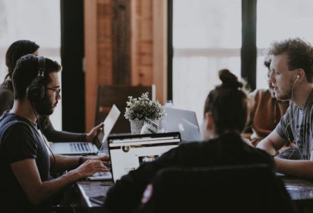 Collaboration Team - selective focus photography of people sits in front of table inside room