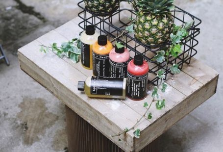Branding Eco - five assorted bottles on brown table beside two pineapples