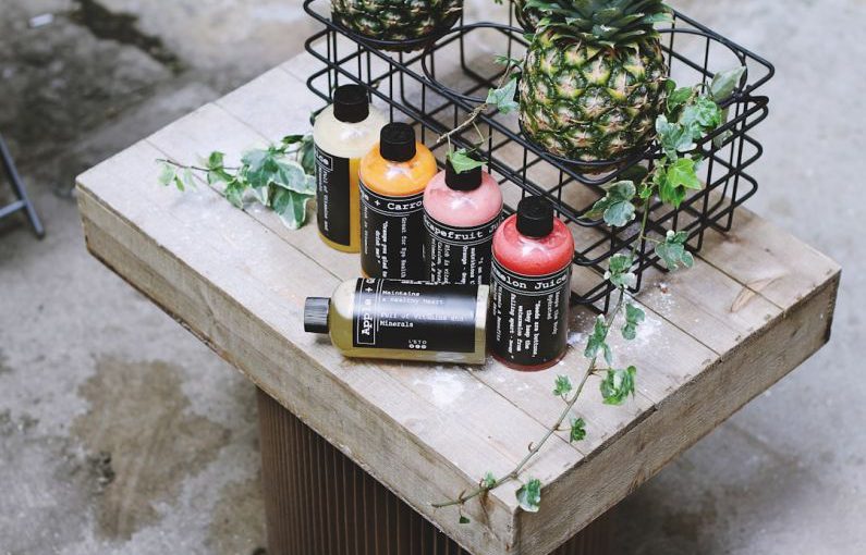 Branding Eco - five assorted bottles on brown table beside two pineapples