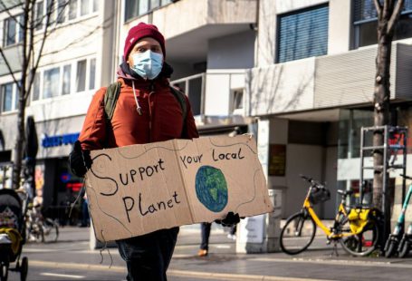Challenges Eco - man in red and black jacket holding brown cardboard box